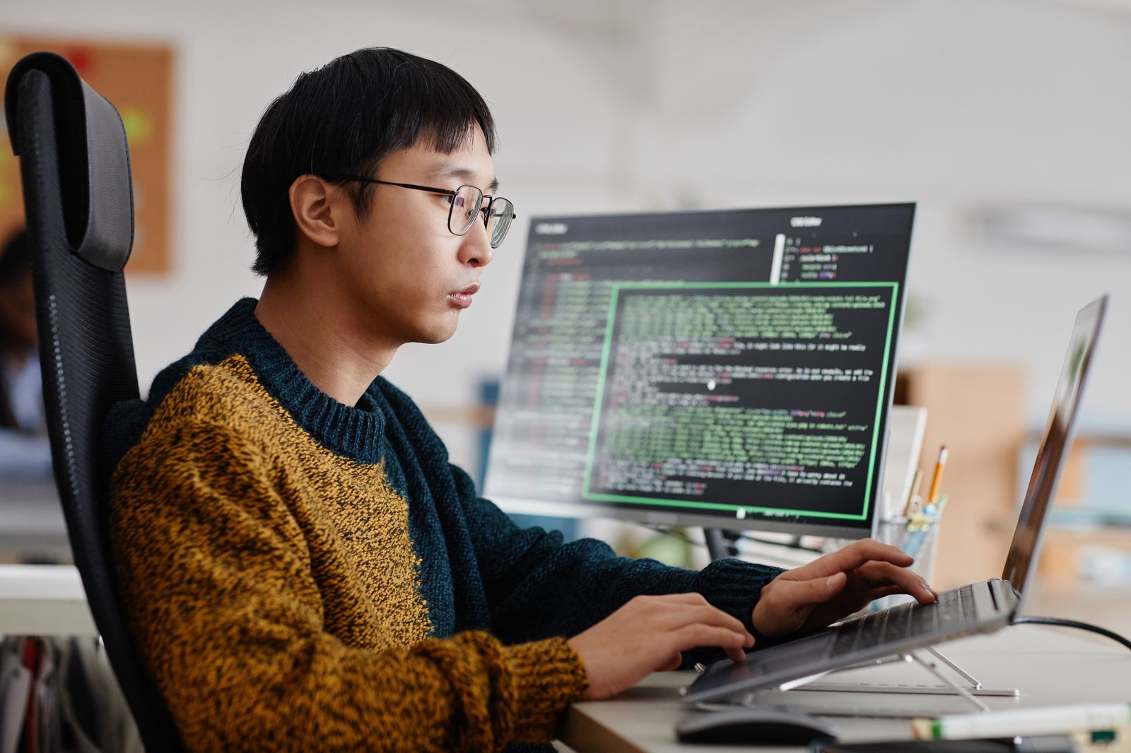 Developer writing code at a workstation in a modern office