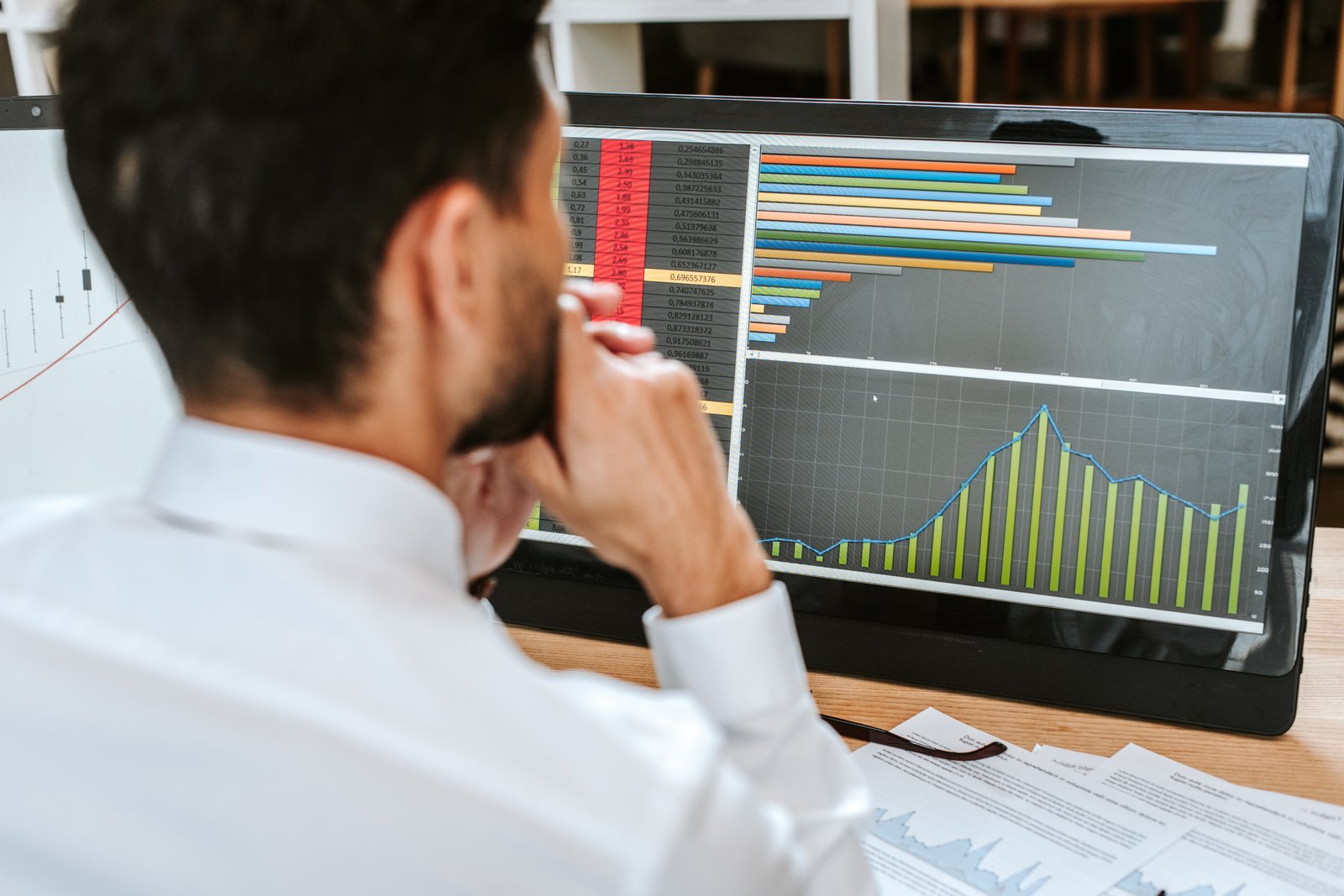 Analyst working with data on a dual-monitor desk